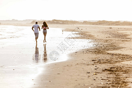 夫妇沿着海滩奔跑图片