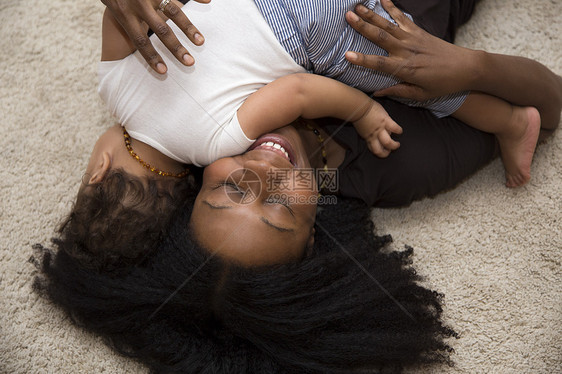中年妇女在地毯上拥抱幼童女儿图片
