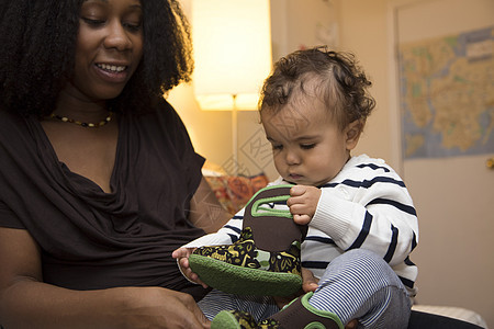 中年妇女和好奇的带婴儿靴的幼童女儿图片