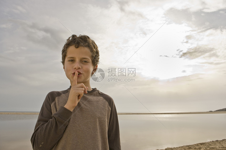 小男孩用手指捂住嘴唇图片