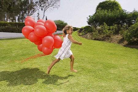 带着红色气球奔跑的年轻女孩图片