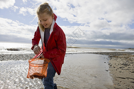小女孩在沙滩上看渔网图片
