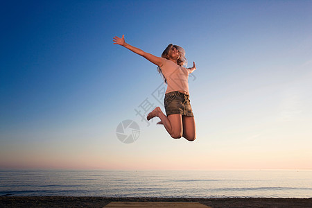 海滩上的女人欢蹦乱跳图片