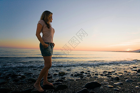 海滩上看日落的女人图片