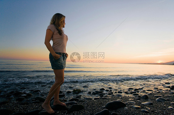 海滩上看日落的女人图片