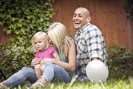 一对幸福的夫妇和幼小的女儿坐在花园里图片