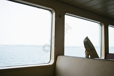 乘客渡船座位上的人手拿报纸图片
