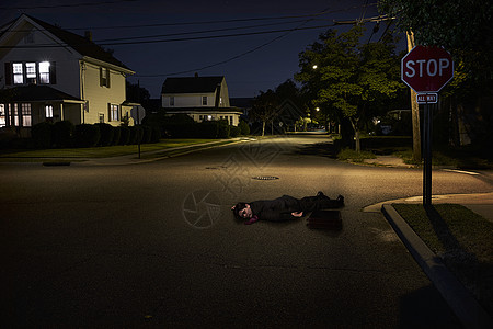 晚上躺在郊区街道上的商人不省人事图片