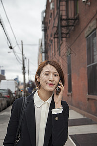 在街上使用智能手机的女商人图片