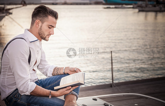 在意大利撒丁岛卡利亚里游艇上读书的年轻人图片
