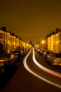 夜间有交通尾灯的住宅街图片