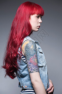 有着红色长发和纹身的年轻女子图片