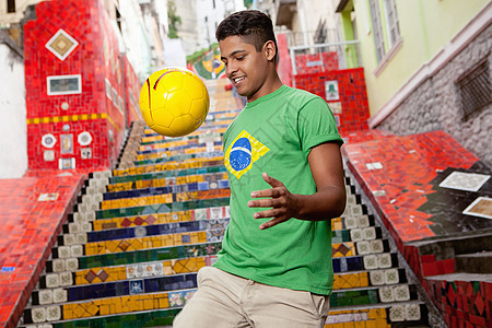 一个穿着巴西上衣的年轻人在埃斯卡达里亚赛拉隆台阶前颠足球背景图片