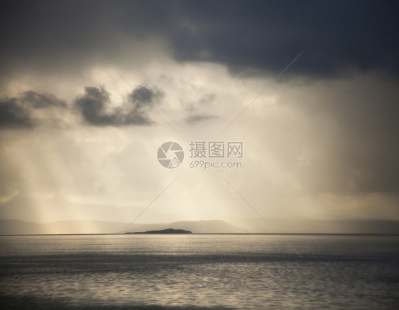 太阳穿过苏格兰高地海上的暴风雨云层图片