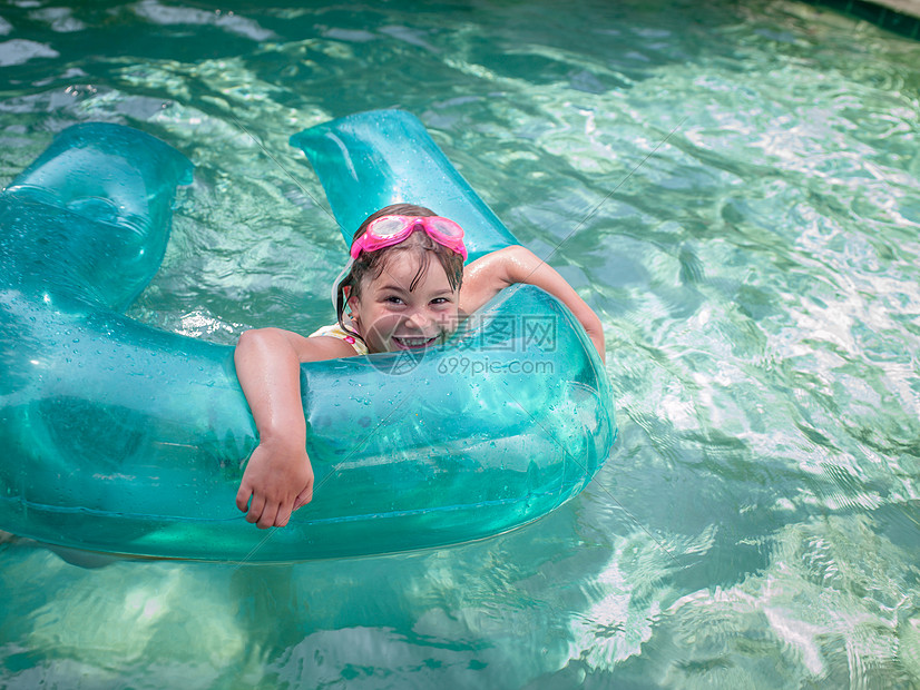 花园游泳池玩充气环的女孩肖像图片