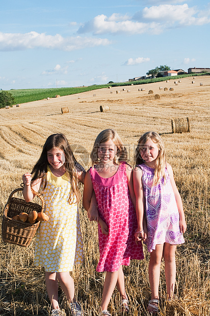 三个女孩站在田野里，肖像图片