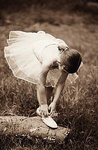 女孩调整她的芭蕾舞鞋背景图片
