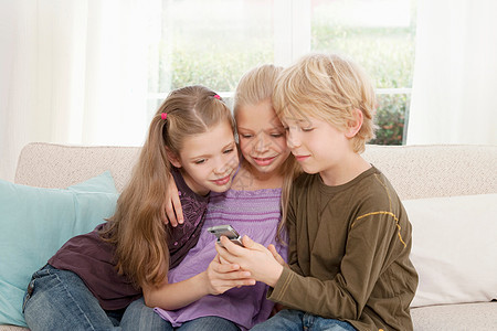 三个孩子在看手机图片