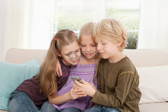 三个孩子在看手机图片