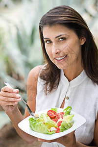 一个女人在外面吃沙拉图片