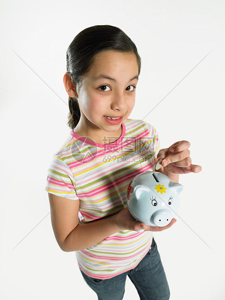 女孩把钱放在存钱罐里图片