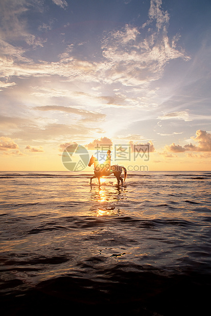 日落时在海上骑马的人图片