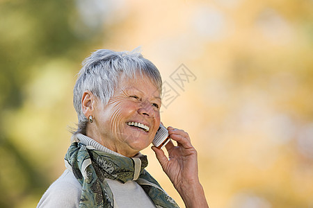 用手机微笑打电话的老年妇女图片