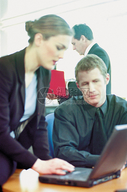 商人和女商人在办公室使用笔记本电脑图片