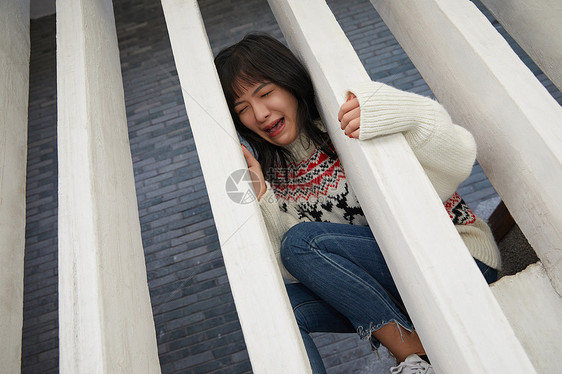 青年女性坐在楼梯上大哭图片