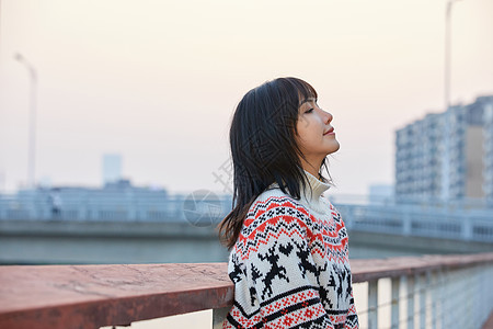 青年女性倚靠栏杆图片