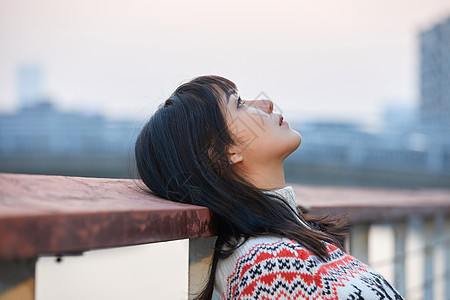 青年女性背靠栏杆图片