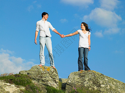 站在大石头上的年轻夫妇图片