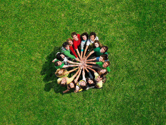 一群人围成一圈站坐在草地上图片