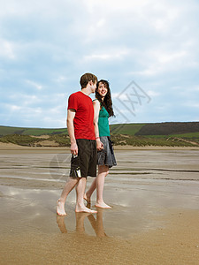 在海滩上散步的年轻夫妇图片