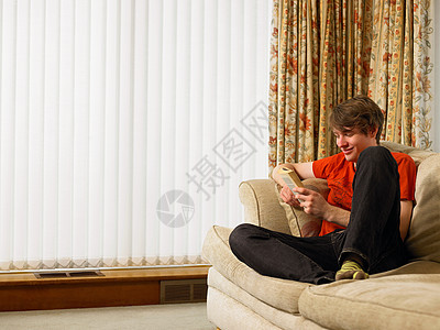 年轻人在沙发上看书图片