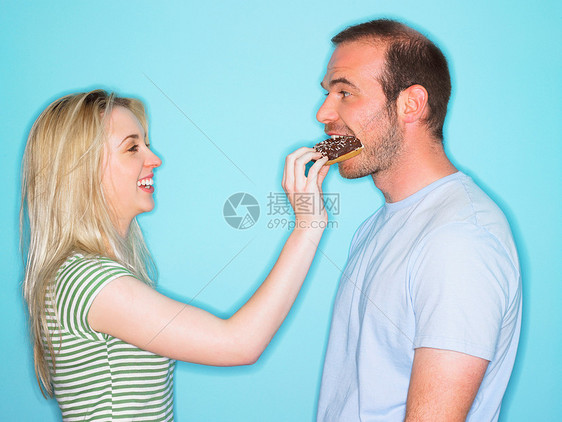 年轻女子用蛋糕喂男人图片