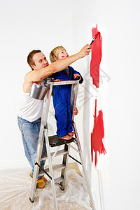 男人和小孩把墙漆成红色图片
