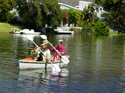 老年夫妇在湖上划独木舟图片