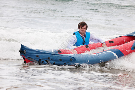 海上推着独木舟的男士图片