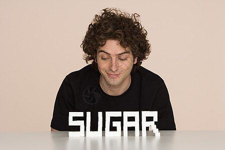 桌子上放糖的年轻人图片