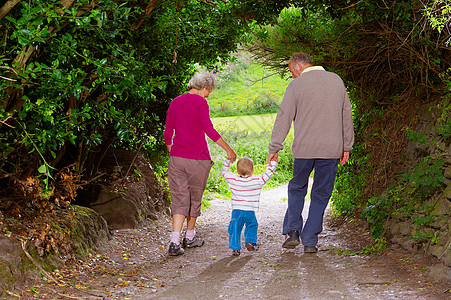 60至69岁带着孩子散步的老年夫妇背景