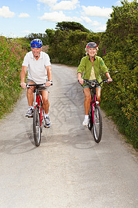 在乡村小路上骑车的老年夫妇图片