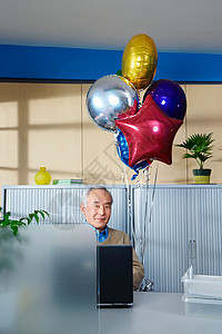 办公桌上拿着气球的老人图片