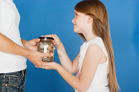 女孩把一罐硬币递给母亲图片