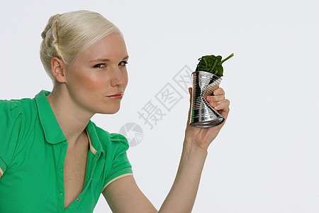 拿着一罐菠菜的年轻女子图片