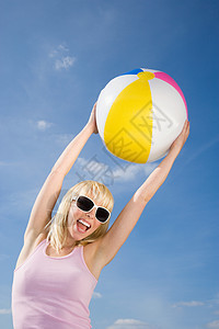 带着沙滩球的年轻女子图片
