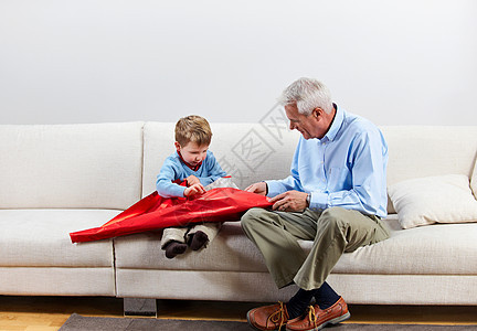 和祖父一起打开礼物的男孩图片