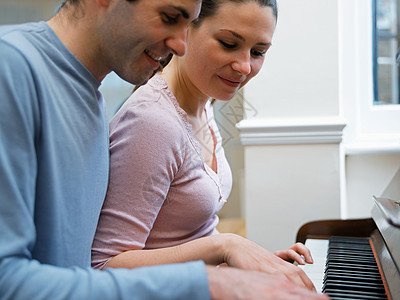 弹钢琴的年轻夫妇图片