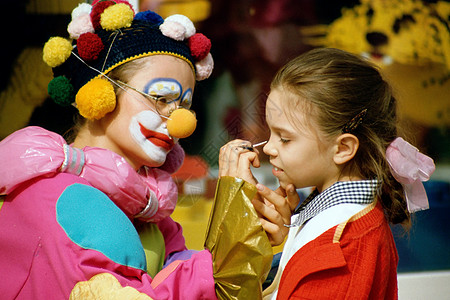 魔术小丑给女孩化妆的小丑背景