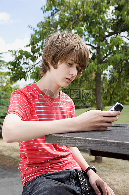 十几岁的男孩看着手机图片
